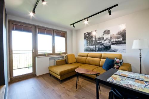 uma sala de estar com um sofá e uma mesa em Apartament Jastrzębie em Jastrzebie-Zdrój