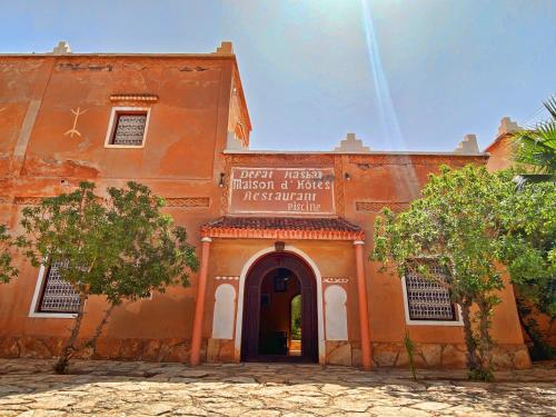 an orange building with an arch in front of it at Guest House Defat Kasbah in Aït Ben Haddou