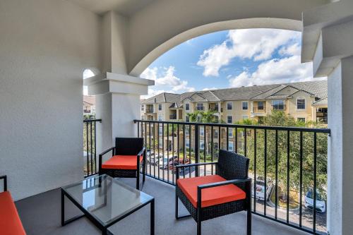 a balcony with two chairs and a view of a building at Newly Renovated Condo wFREE Resort Access in Orlando