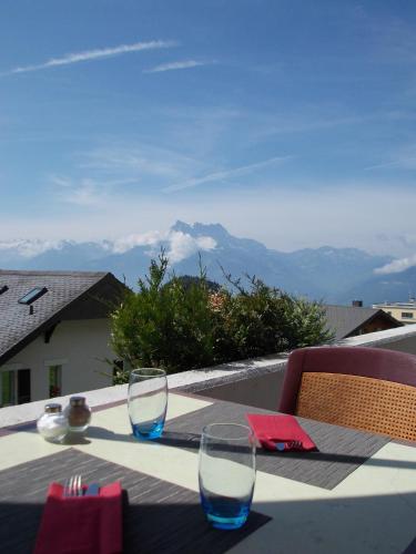 two glasses sitting on a table with a view of mountains at Alpine Classic Hotel in Leysin