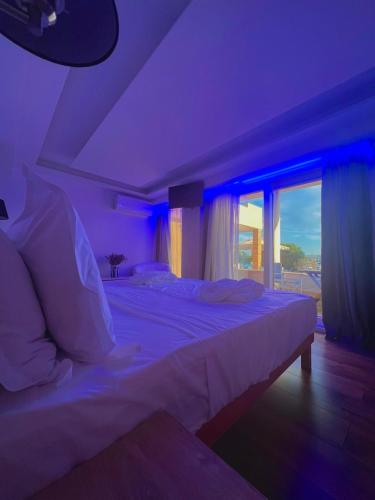 a bedroom with a large bed with blue lighting at Rozos Hotel in Porto Heli