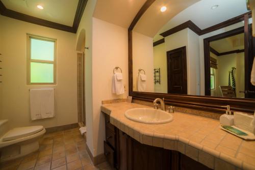 a bathroom with a sink and a toilet and a mirror at Los Suenos Resort Marbella 2A in Herradura