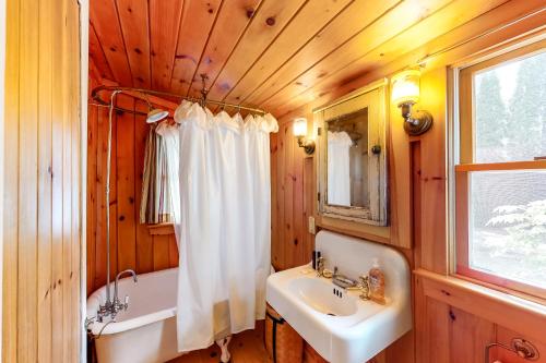 y baño con lavamanos, bañera y lavamanos. en Wellhouse Cottage, en Standish