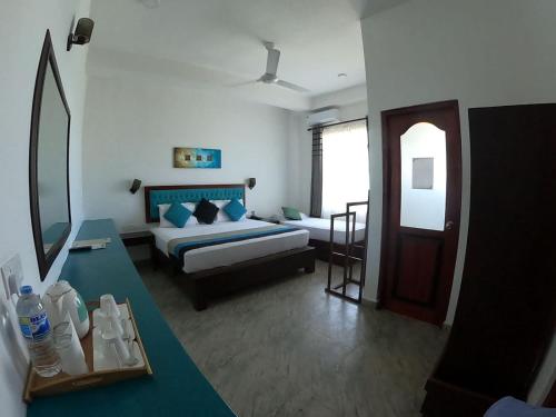 a living room with a bed and a couch at The Bay in Arugam Bay