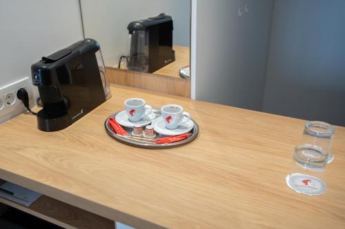 a counter with two cups and a coffee machine at Hotel Küküllő - Târnava in Odorheiu Secuiesc