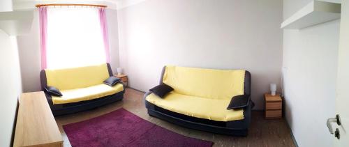 2 sillas amarillas en una habitación con ventana en Domek letniskowy SZARACZEK en Okuninka