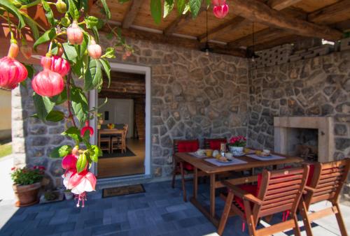 a dining room with a table and a stone wall at Guest house 'Villa Fani' Veprinac with jacuzzi in Veprinac