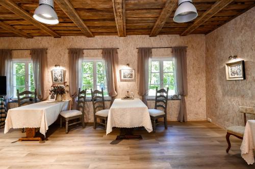 a dining room with two tables and chairs and windows at UKI Puhkeküla in Ranna