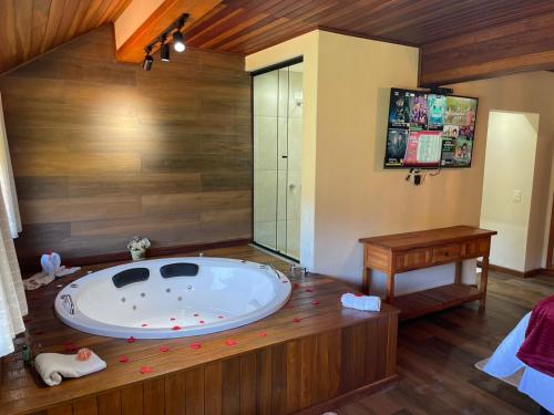 a large bathroom with a large tub in a room at Hotel Pião Mineiro in Monte Verde