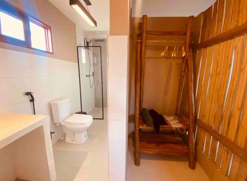 a bathroom with a toilet and a shower and a sink at Loft Canoa in Aracati