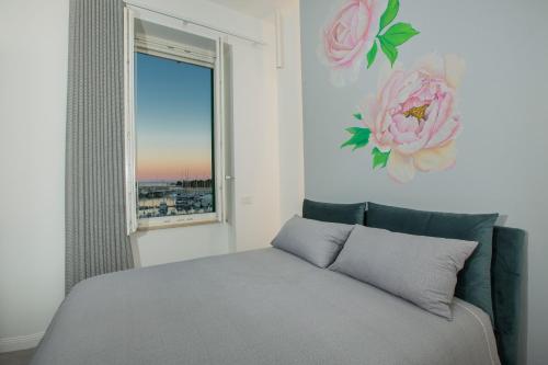 a bedroom with a bed with a flower on the wall at Residenza Rebecca in Trani