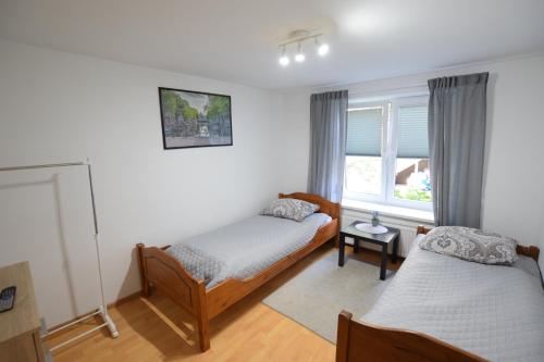 a bedroom with two beds and a window at Johnny House in Suwałki
