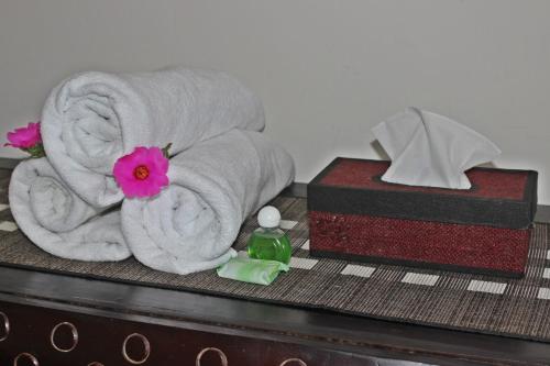 a pile of towels and a box with a pink flower at Dangin Mangkalan Homestay in Munduk
