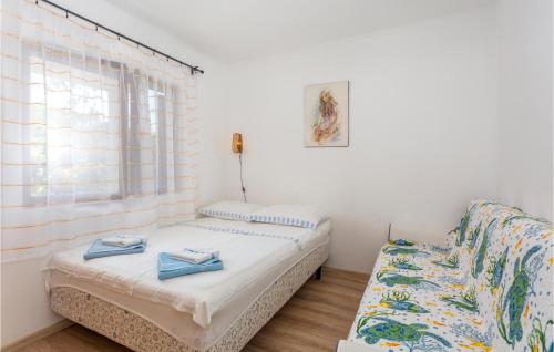 Cette chambre comprend deux lits, un canapé et une fenêtre. dans l'établissement Beautiful Apartment In Gabonjin With Kitchen, à Gabonjin