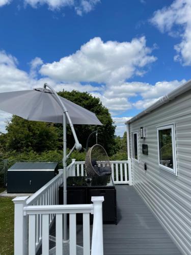 a deck with an umbrella and a grill at Turlin Valley in Poole