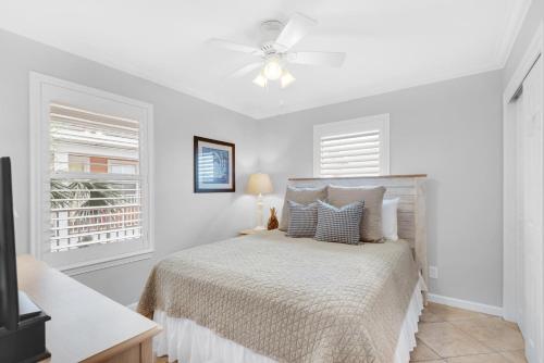 a white bedroom with a bed and a ceiling fan at Gulfview II 318 in Destin
