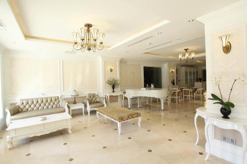 a living room with white furniture and a chandelier at CityBay Palace Hạ Long Hotel in Ha Long