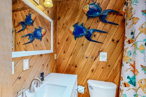 ein Bad mit blauem Fisch an der Wand in der Unterkunft Pines Cottage in Standish
