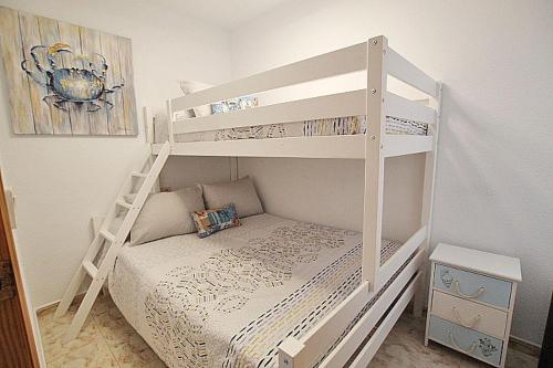 Litera blanca en una habitación pequeña en APN Apartamento Playa de Guardamar, en Guardamar del Segura