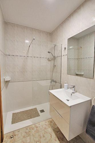 a white bathroom with a shower and a sink at APN Apartamento Playa de Guardamar in Guardamar del Segura