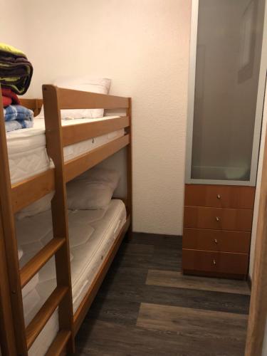 - une chambre avec des lits superposés, une commode et un miroir dans l'établissement Appartement vue mer le barcares, au Barcarès