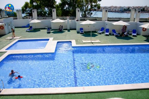 a swimming pool with people playing in the water at Apartamentos Marino Superior Casa Azahar in Alcossebre