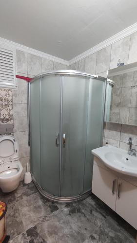 a bathroom with a shower and a toilet and a sink at Uzungöl Zahra Apart Hotel in Uzungöl