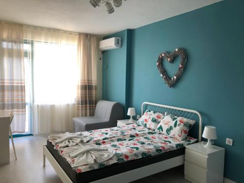 a bedroom with a bed with a heart mirror on the wall at Studio N in Primorsko