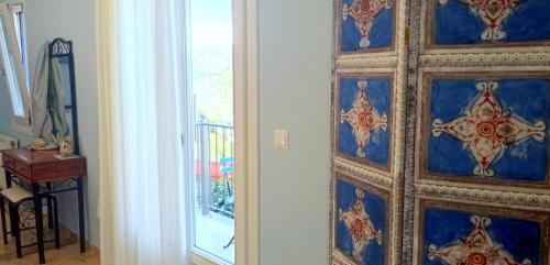 a room with a wall with blue and red tiles at Odysseion Apartments in Vathi, Ithaka
