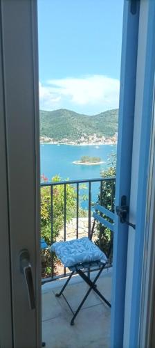 a balcony with a chair and a view of the ocean at Odysseion Apartments in Vathi, Ithaka