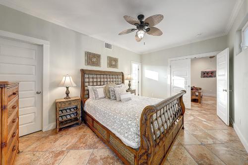 una camera da letto con un letto e un ventilatore a soffitto di Pipeline Manor a Port Aransas