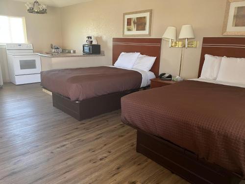 una camera d'albergo con due letti e una cucina di Valley Motel ad Alamosa