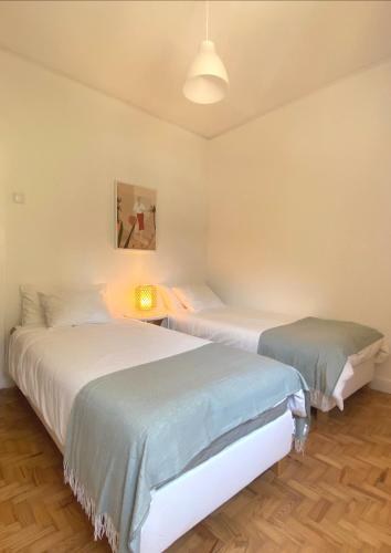 a bedroom with two beds and a lamp in it at Lisboa Central Apartment in Lisbon