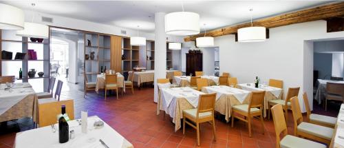 a dining room with white tables and chairs and a restaurant at Hotel Romanda in Levico Terme