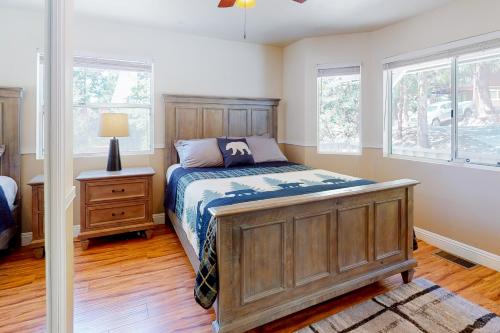 a bedroom with a bed and two windows at Tree-Top Getaway in Lake Arrowhead