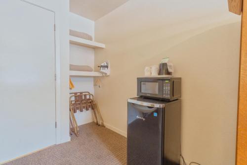 a small room with a microwave on top of a refrigerator at Mariposa Lodge in Mariposa