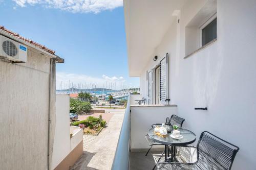 een balkon met een tafel en stoelen en uitzicht op de oceaan bij Apartments and Rooms Mare in Vodice