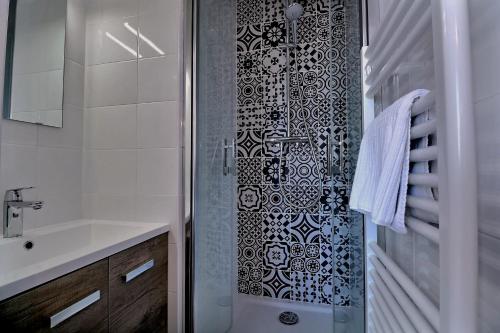 a bathroom with a shower with a sink and a toilet at Appartement "MEZZA" centre ville de VITRÉ in Vitré