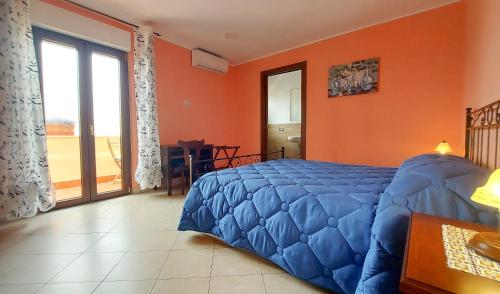 ein Schlafzimmer mit einem blauen Bett und einer orangefarbenen Wand in der Unterkunft CORSO MARCONI HOUSE in Civitavecchia