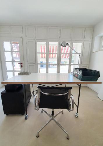 an office desk with a lamp and a chair at Alte Goldschmiede Südpfalz in Klingenmünster