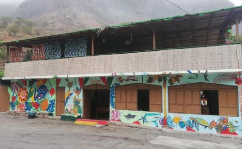 ein Gebäude mit einem Wandbild an der Seite in der Unterkunft gîte de rando haut in Mato Correia