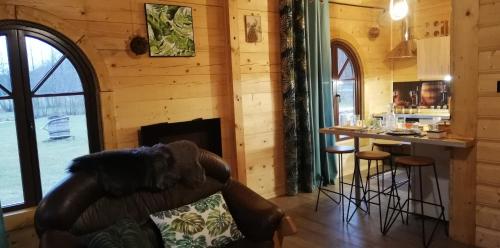 a living room with a bar in a log cabin at Woodorf drewnem usłane - domki z bala nad rzeką Słupią wśród pól i lasów z chatą grillową, ogniskiem i placami zabaw dla dzieci -Royal Red House z jacuzzi i ogrodzonym extra ogródkiem dla piesków, Royal Green House - bez jacuzzi in Ustka