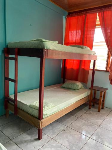 two bunk beds in a room with a window at Cabinas Popular in Puerto Viejo