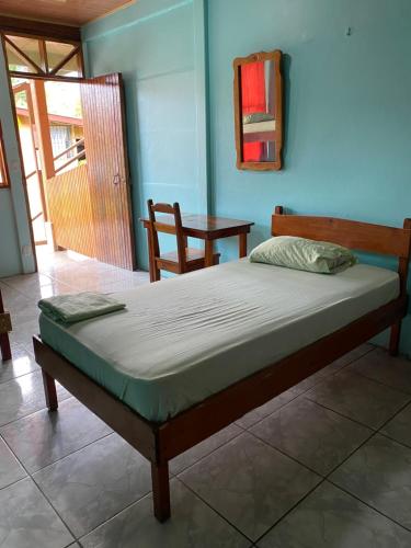 uma cama num quarto com uma moldura de madeira em Cabinas Popular em Puerto Viejo