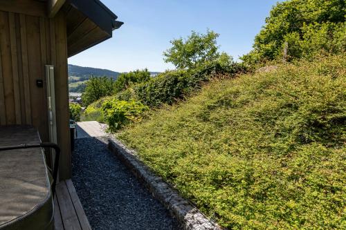 a view from the porch of a cabin with a grassy hill at Le Petit Moussis in Stavelot