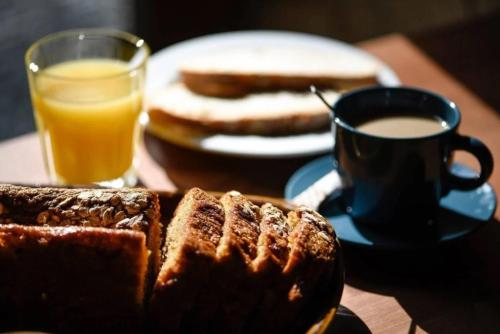 a table with a plate of bread and a cup of coffee at Abeiro da loba in Madelos