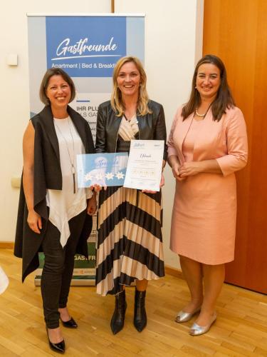 three women standing next to each other holding a certificate at Ferienhaus Melita in Bleiburg