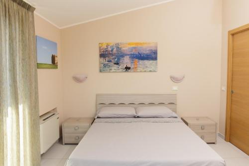 a bedroom with a bed and a painting on the wall at La Collina sul Mare Apartments in Petacciato
