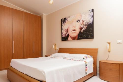 a bedroom with a bed with a large painting on the wall at La Collina sul Mare Apartments in Petacciato