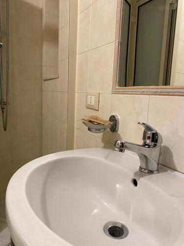 un lavandino bianco in un bagno con uno specchio di Etna Rosso b&b a Catania